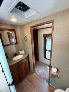 RV bathroom with sink, mirror, and window for natural light.