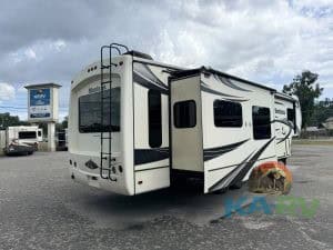 Travel trailer with slide-out parked on lot, ready for repair or maintenance services. Ideal for RV.