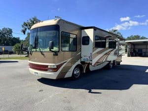 Spacious motorhome parked outdoors with clear blue sky.
