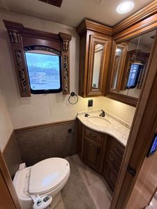 Luxury RV bathroom with wooden cabinets and modern fixtures.