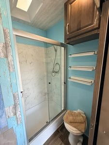 Bathroom shower with glass enclosure and blue walls.
