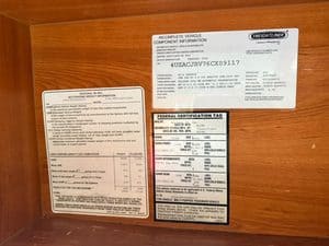 Incomplete vehicle component info label on RV with certification tags.