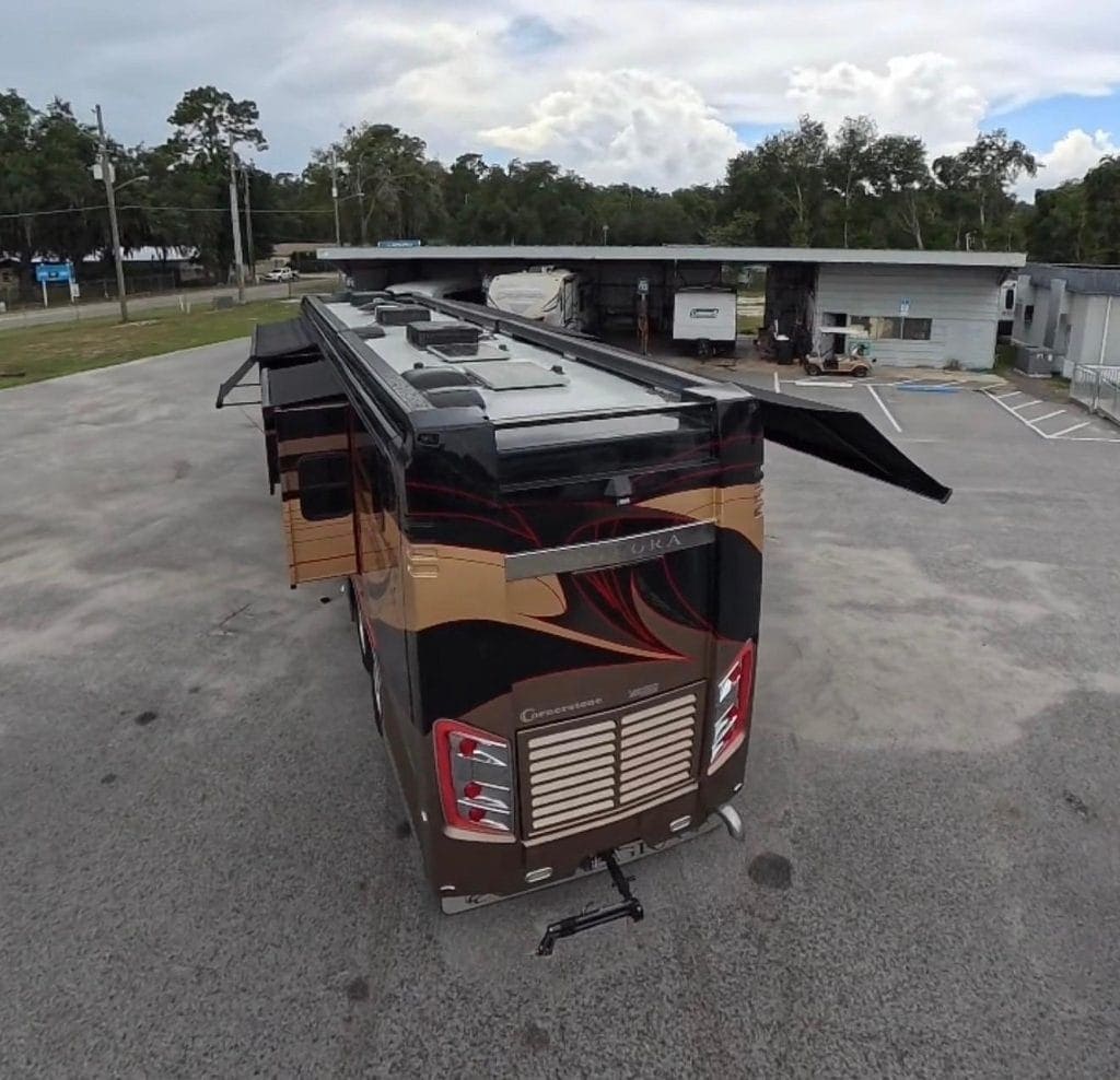 Luxury RV parked outdoors with slide-out extended, showcasing high-end features.