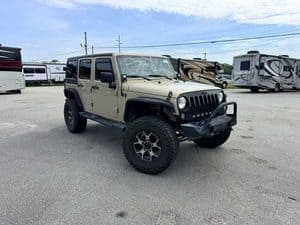 Jeep Wrangler in RV dealership lot with RVs in background.