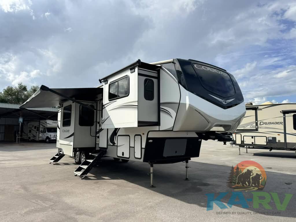 Luxury fifth wheel RV parked outdoors with slide-outs extended.