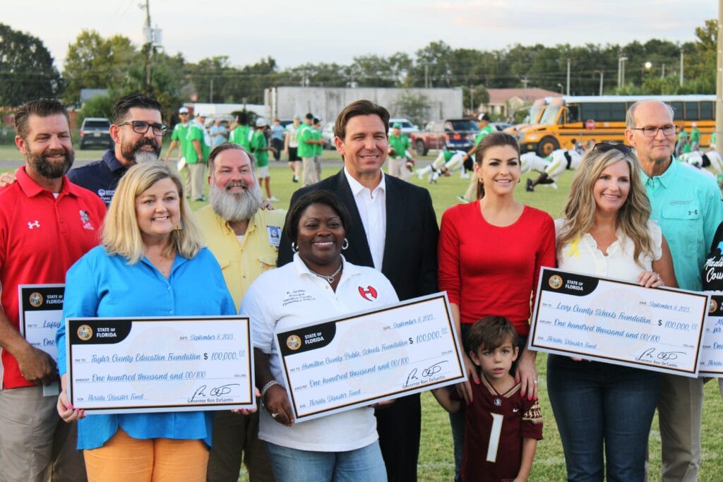 Gov. Ron DeSantis and first lady Casey DeSantis present checks for Hurricane Idalia relief.