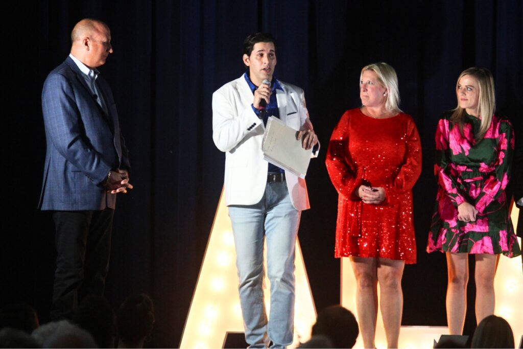 Adam Boukari, center, and chamber board members present Mitch Glaeser, left, with a pocket watch from the 1899 Worlds Fair.