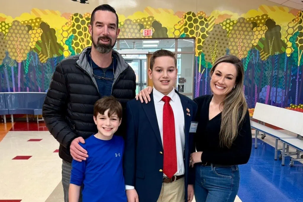 Cooper Campen (jacket and tie) surrounded by his family after he won the spelling bee.