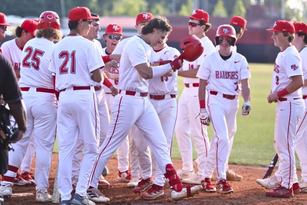 Santa Fe's Dylan Lovelace (helmet off) gets congratulated by teammates after hitting a two-run home run in the first inning against Gainesville.
