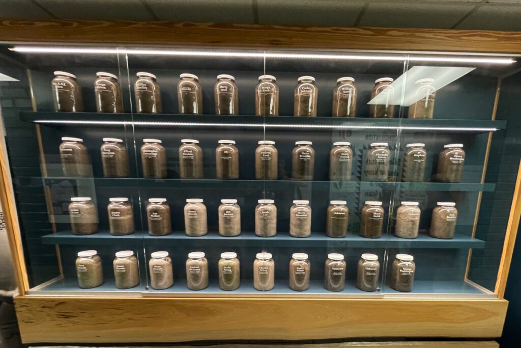Jars of soil lined in a bookcase