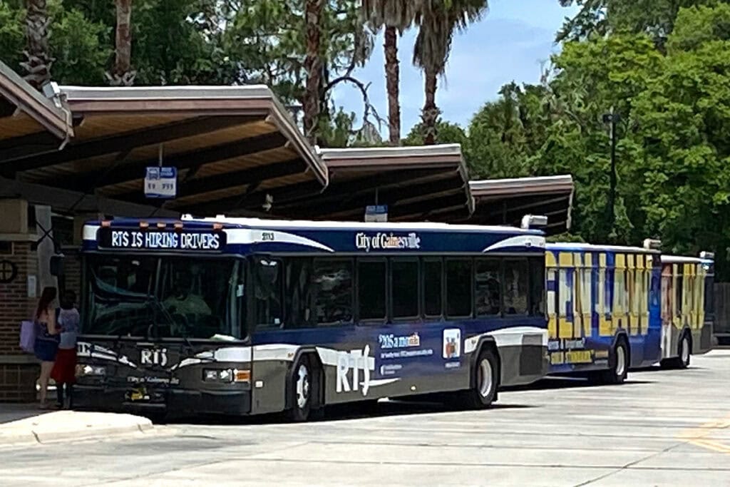 Three Regional Transit System buses lined up at the Rosa Parks Transfer Station in Gainesville.