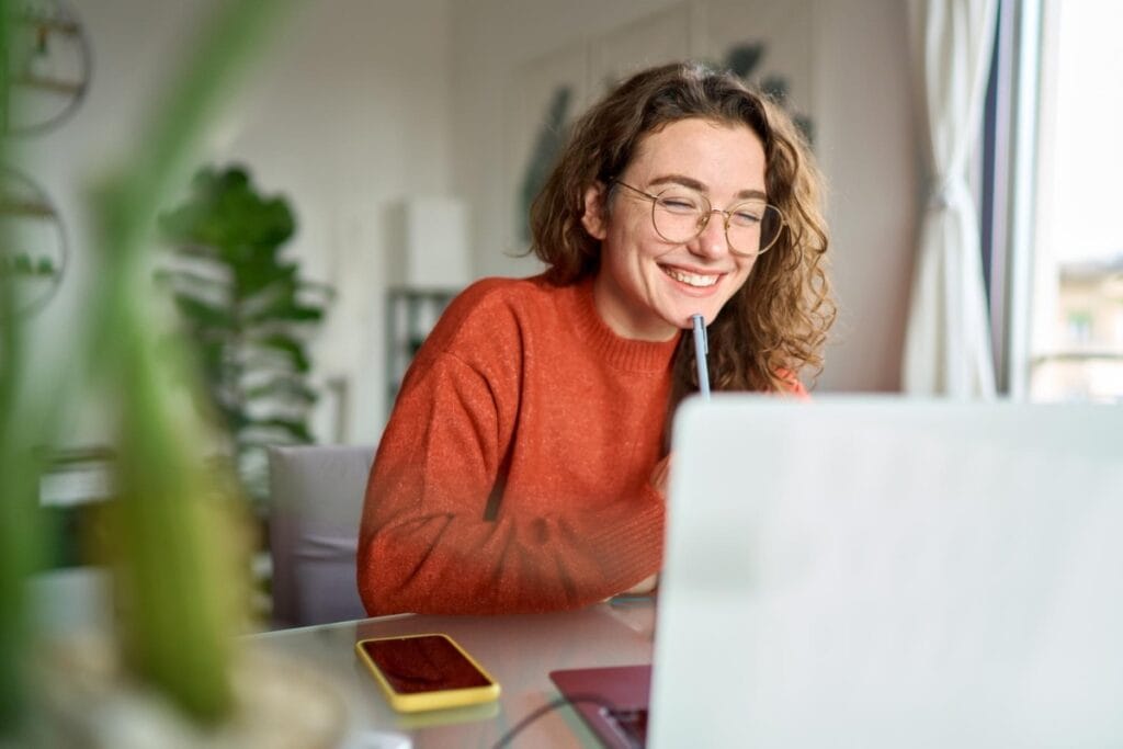 Student smiling at laptop