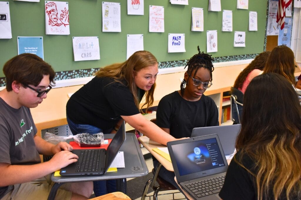Instructional Technology coach Christina Cole helps SFHS students log into their new laptops.