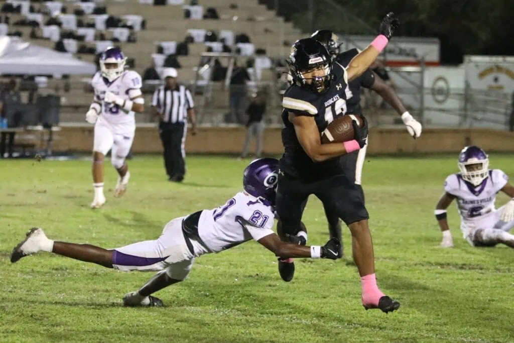 Buchholz's Justin Williams (13) slips through the arms of Gainesville's Demetrius Debose (21) in the first quarter on Friday.