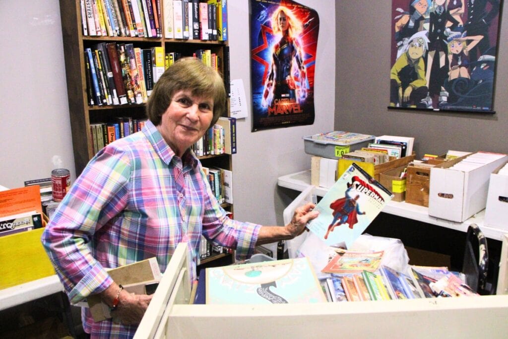 Friends of the Library volunteer Sue Morris looks through comics. Photo by Lillian Hamman