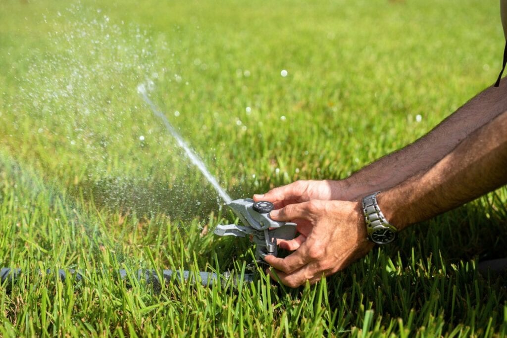 A person sets the lawn sprinkler to the proper setting. Cristina Carrizosa UF-IFAS
