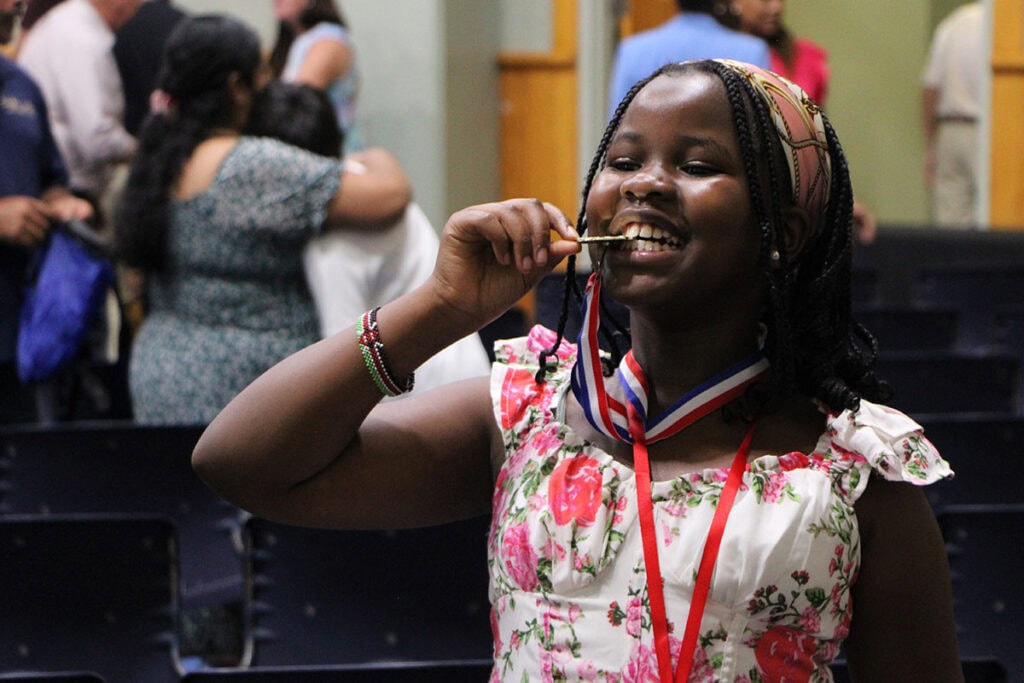 Metcalfe Elementary School's Citizen of the Year June Koech bites her medal in celebration.