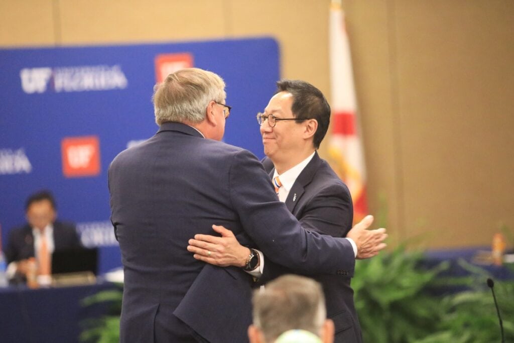 Interim UF President Kent Fuchs shakes hands and hugs Dr. Santa Ono after his confirmation by the Board of Trustees.