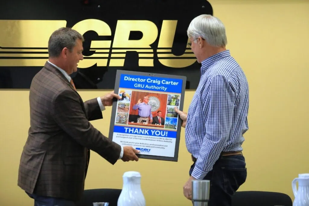 Chair Eric Lawson presents Director Craig Carter with a plaque commemorating his term on the GRU Authority.
