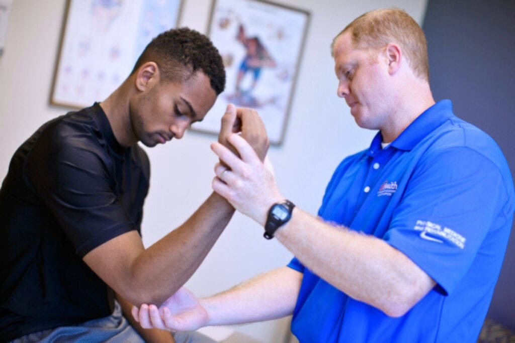 UF Health Department of Physical Medicine and Rehabilitation's Dr. Jason Zaremski (right) examines an elbow. Courtesy of UF Health