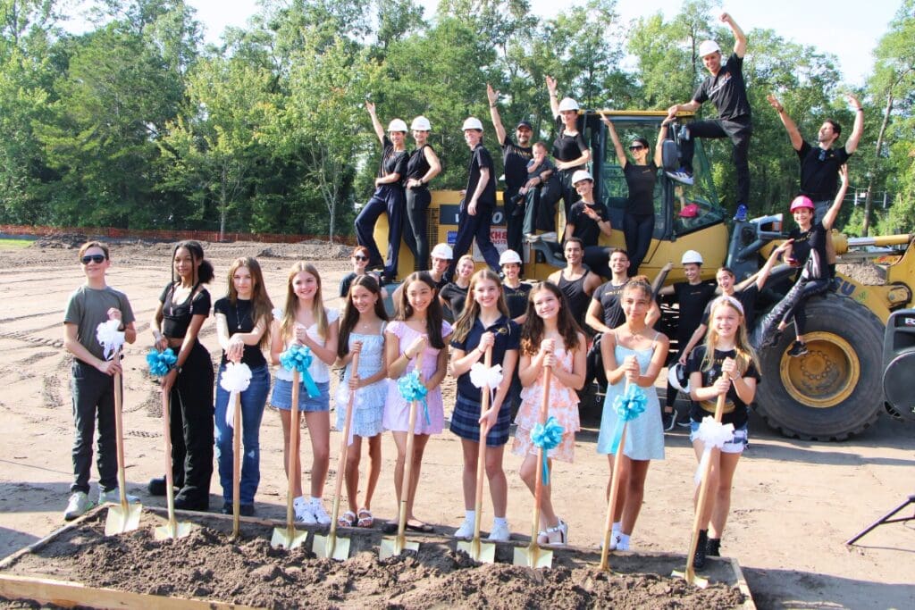 Dance Alive dancers climb up construction equipment to celebrate their new studio's groundbreaking. Photo by Lillian Hamman