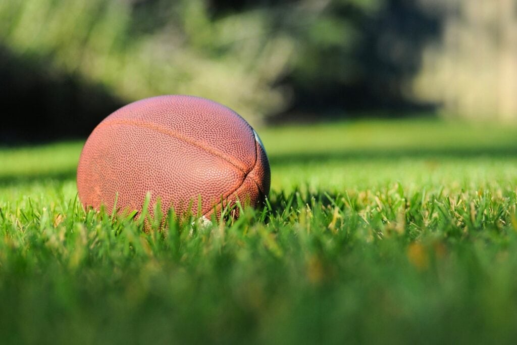 Football in grass. Photo by Ben Hershey-Usplash