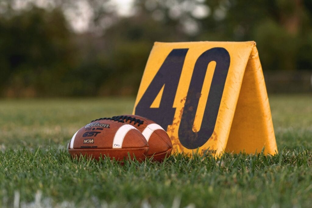 Footballs and yard marker. Photo by Timothy Johnson-Unsplash