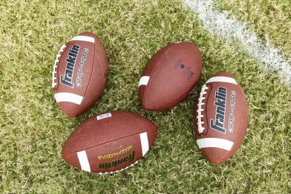 Four footballs. Photo by Mick Haupt-Unsplash