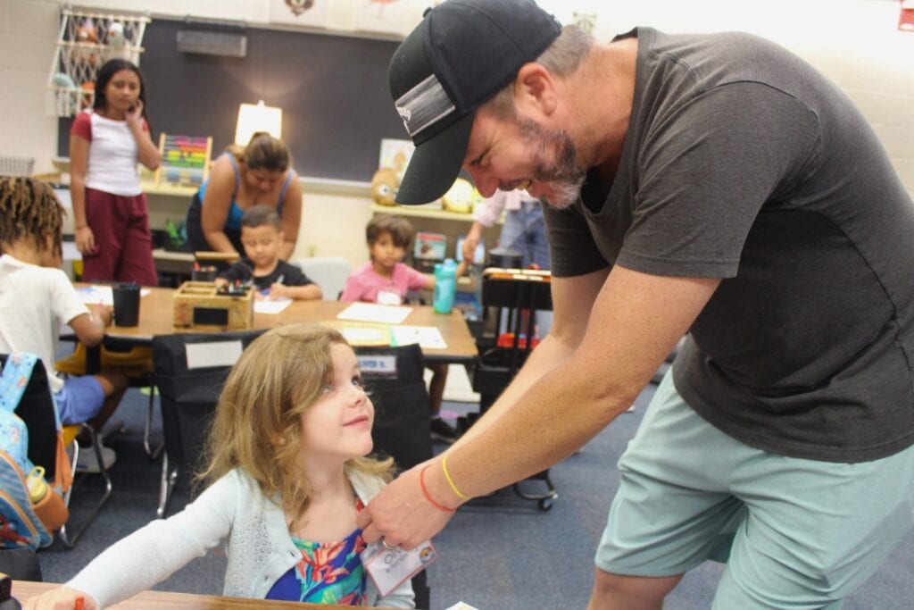 Jeff Rifenberg pins a name tag on the shirt of his daughter, Olivia Rifenberg, on Monday morning. Photo by Nick Andhulz
