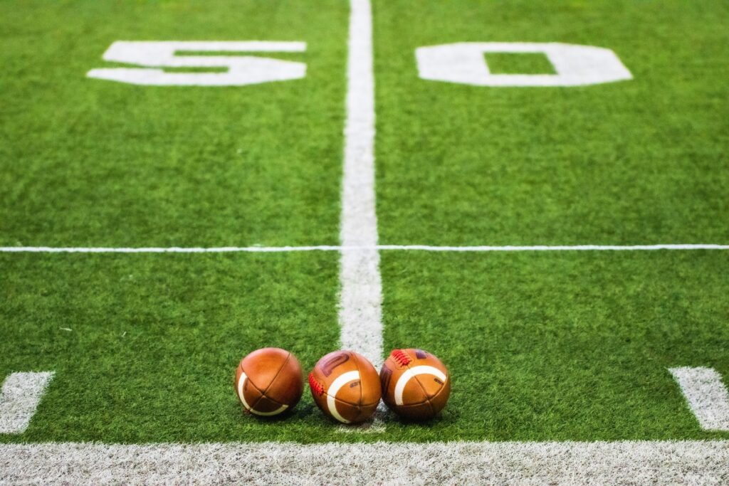 Three footballs on field.
