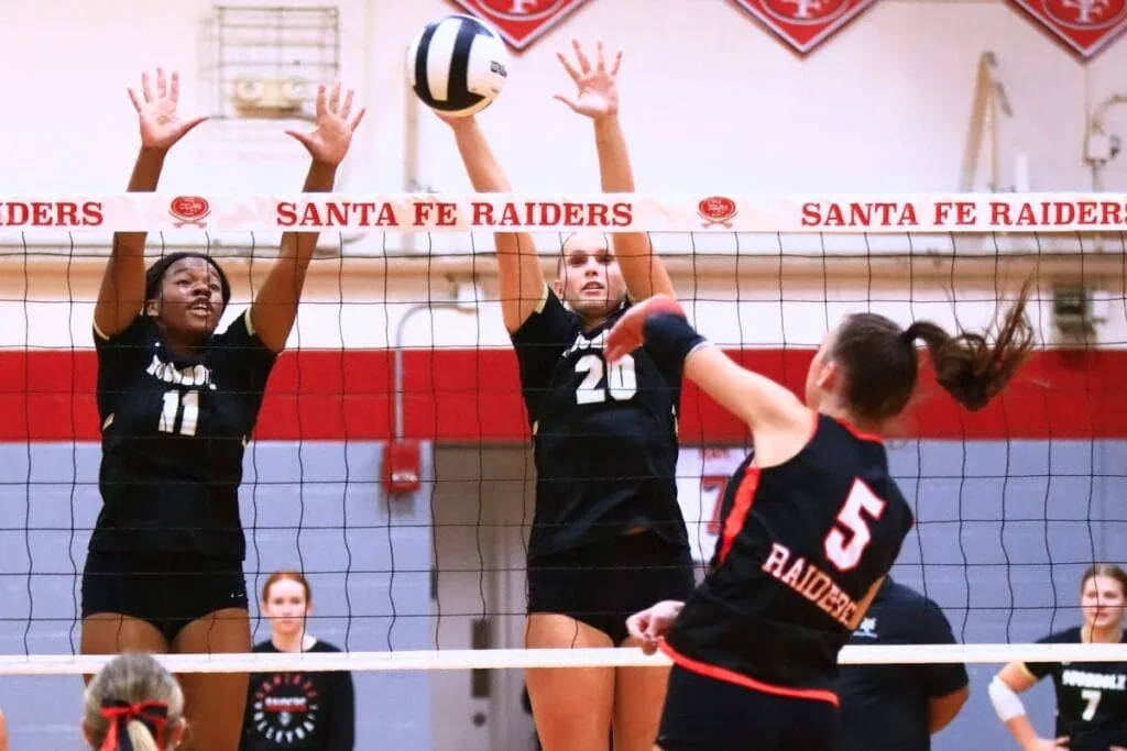 Buchholz's Demmi Strappy (11) and Aubrey Waters (20) attempt to block a hit by Santa Fe's Ella Schneider. Photo by C.J. Gish