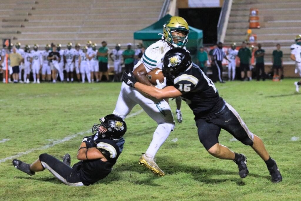 Buchholz's Troy Fleming (2) and Evan Walker (15) combine for a tackle on a Nease (Ponte Vedra) runner. Photo by Seth Johnson
