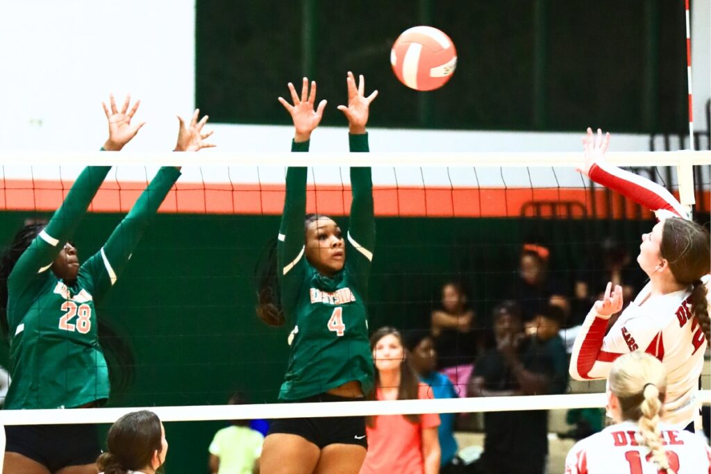 Dixie County's Katilyn Sikes (2) with a hit against Eastside's Taylor Flowers (28) and Neeah Mewborn (4). Photo by C.J. Gish