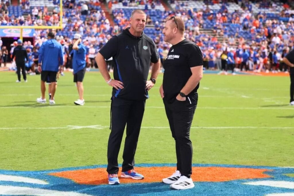Florida coach Billy Napier and USF's Alex Golesh catch up before Florida's 18-16 loss to the Bulls on Saturday. Photo Maddie Washburn-UAA Communications