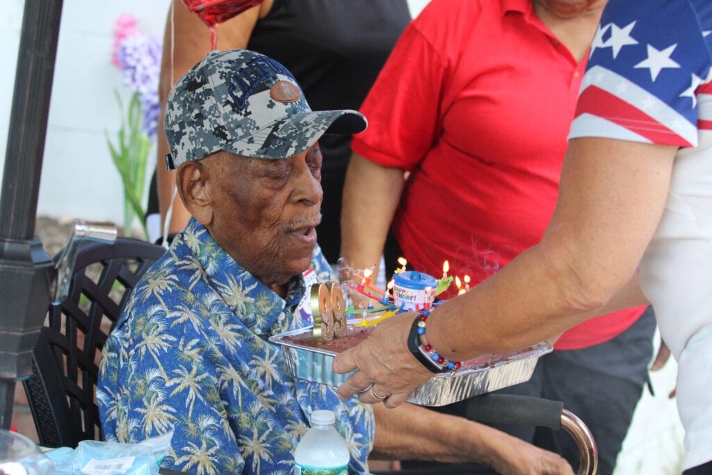 Joseph Williams blows out candles for his 99th birthday. Photo by Seth Johnson