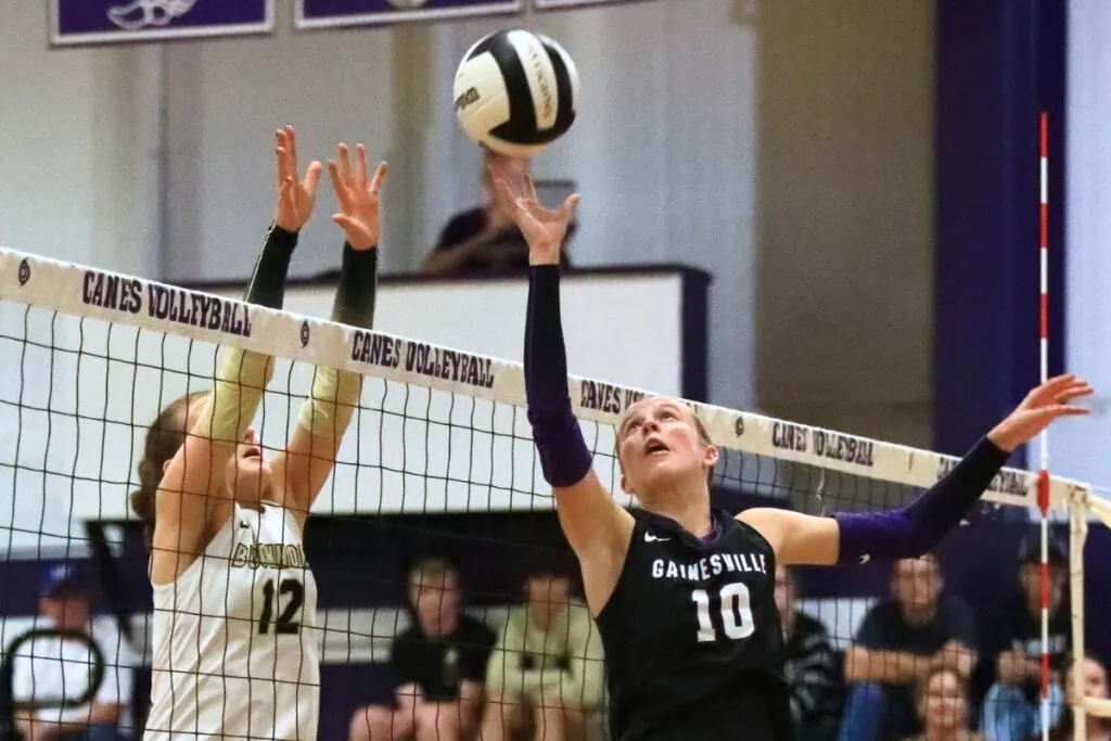 Buchholz's Taylor Sembower (12) and Gainesville's Charlotte Judge (10) go after the ball at the net. Photo by C.J. Gish