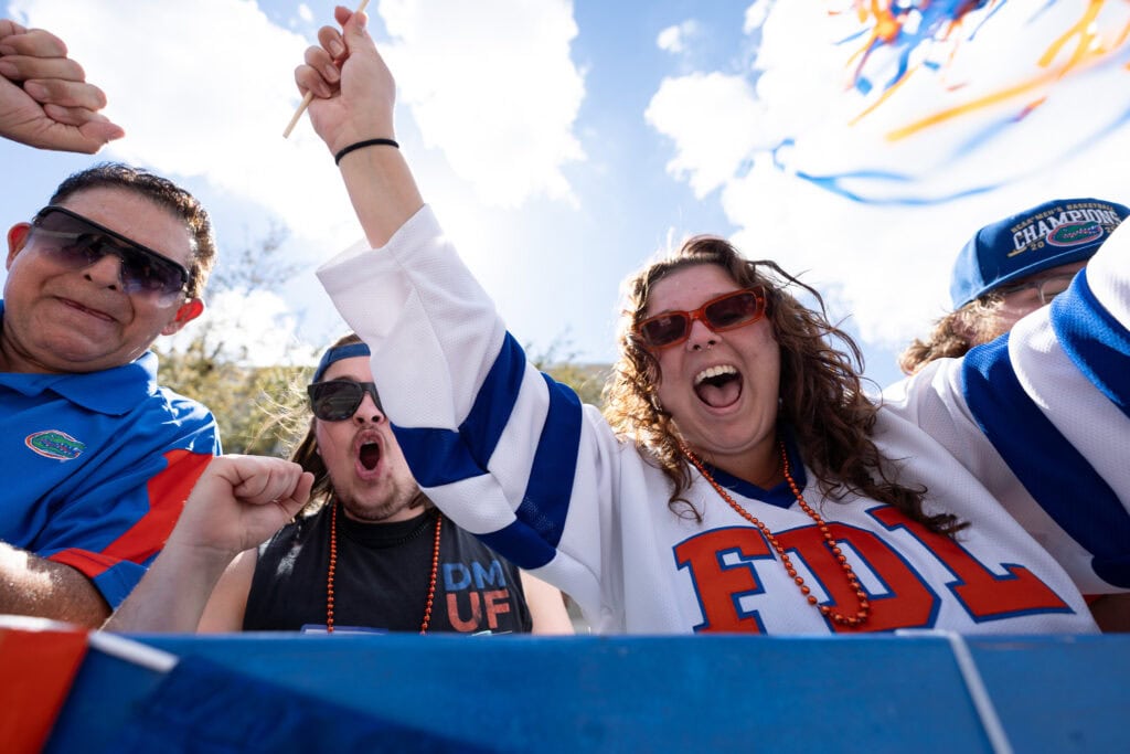 Lena Hammond (right) and Carter Erickson (rear) cheering for the Orange and Blue during the UF Homecoming Parade