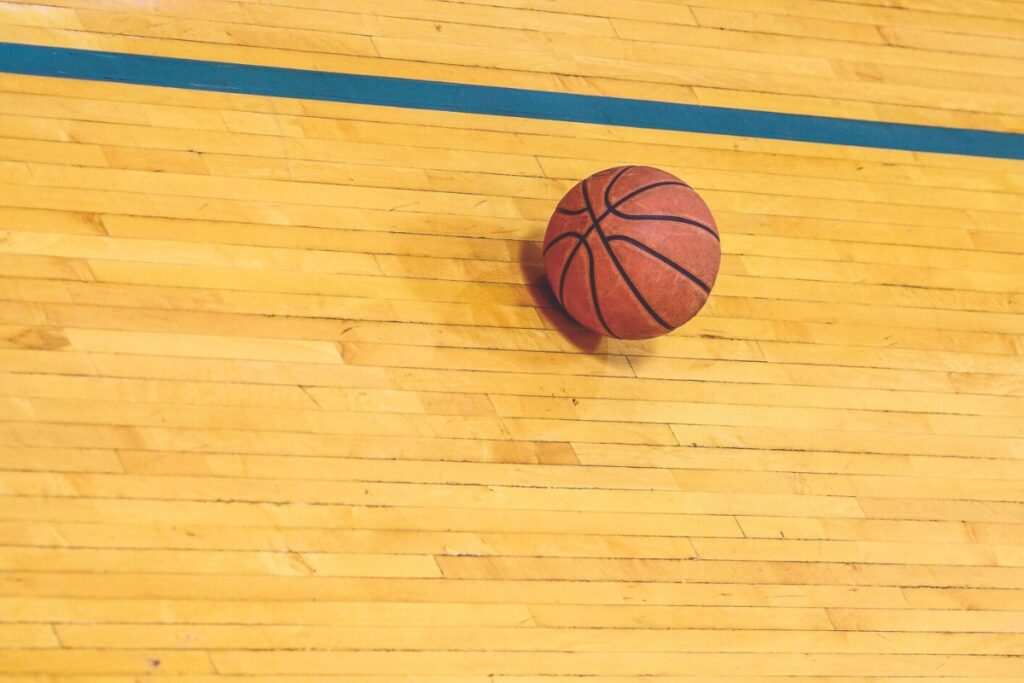 Basketball on hardwood court. Metro Creative