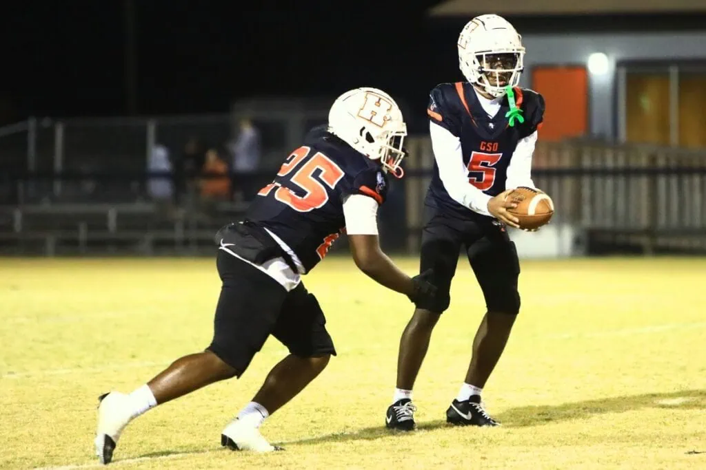 Hawthorne quarterback Richard Roundtree Jr. (5) hands off to Derryek Gillins. Photo by C.J. Gish