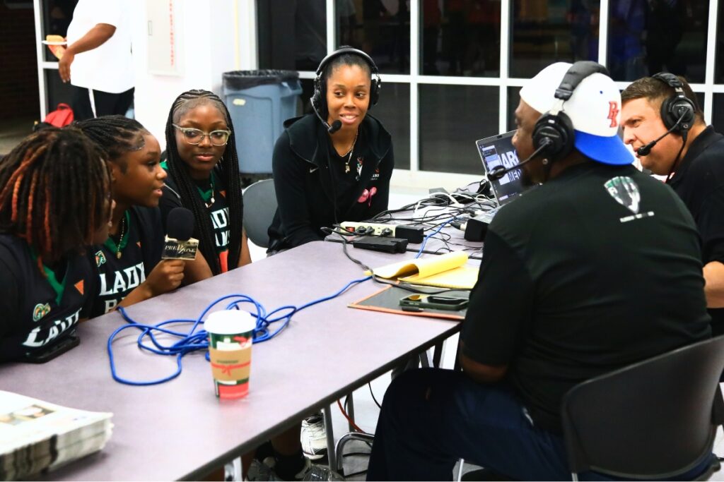 Mainstreet correspondent Marty Pallman (left) and former coach Mac McCray (second from left) interview Eastside players and coach Lonna Turner at the media day held on Nov. 7 at GHS.