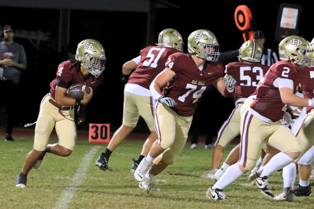 Oak Hall quarterback Aaron Akins keeps the ball for a run against Christ's Church Academy (Jacksonville). Photo by Seth Johnson