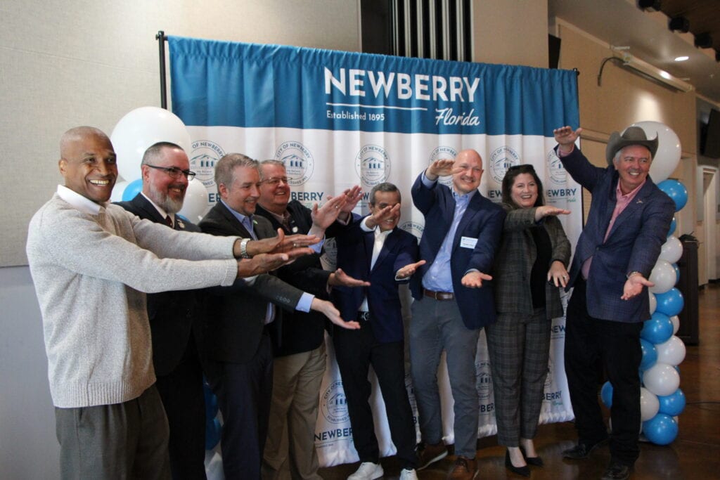 Press conference attendees do the UF Gator chomp to celebrate Harvest Singularity in Newberry. Photo by Lillian Hamman