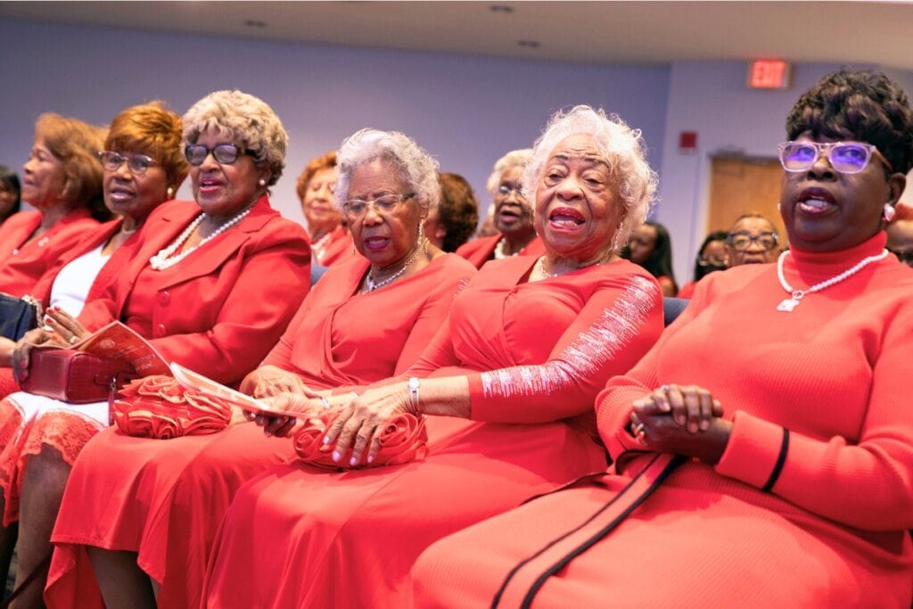 The Charmettes’ Alachua County charter members Janie Williams (fourth from left) and Bettye Jennings (fifth from left) wore matching dresses and accessories to the event. Photo by Megan V. Winslow
