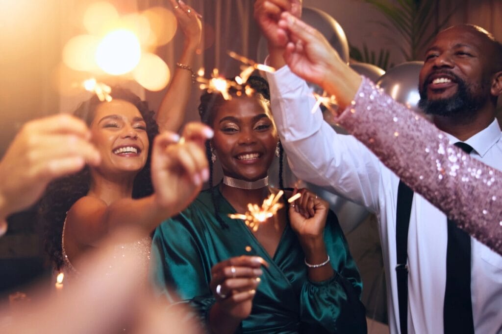 A new year is a chance to embrace a wallet-friendly mindset and make a fresh financial start. People celebrating new year with sparklers.