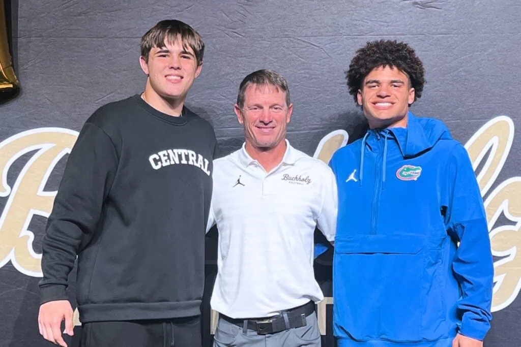 Buchholz's Evan Walker (left) and Justin Williams (right) with head football coach Mark Whittemore at college signing day. Photo by Mike Ridaught