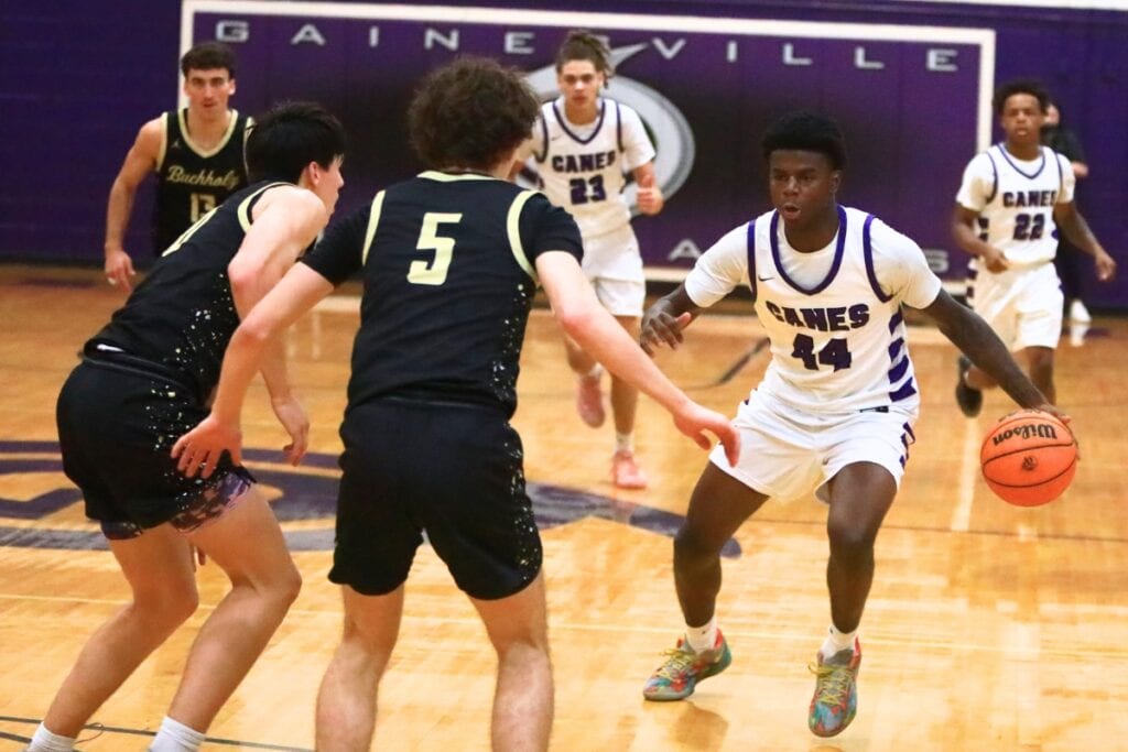Gainesville's Antonio Hall (44) dribbles down the floor against Buchholz's Jacob Bromirski (0) and Lucas Bhatia (5). Photo by C.J. Gish