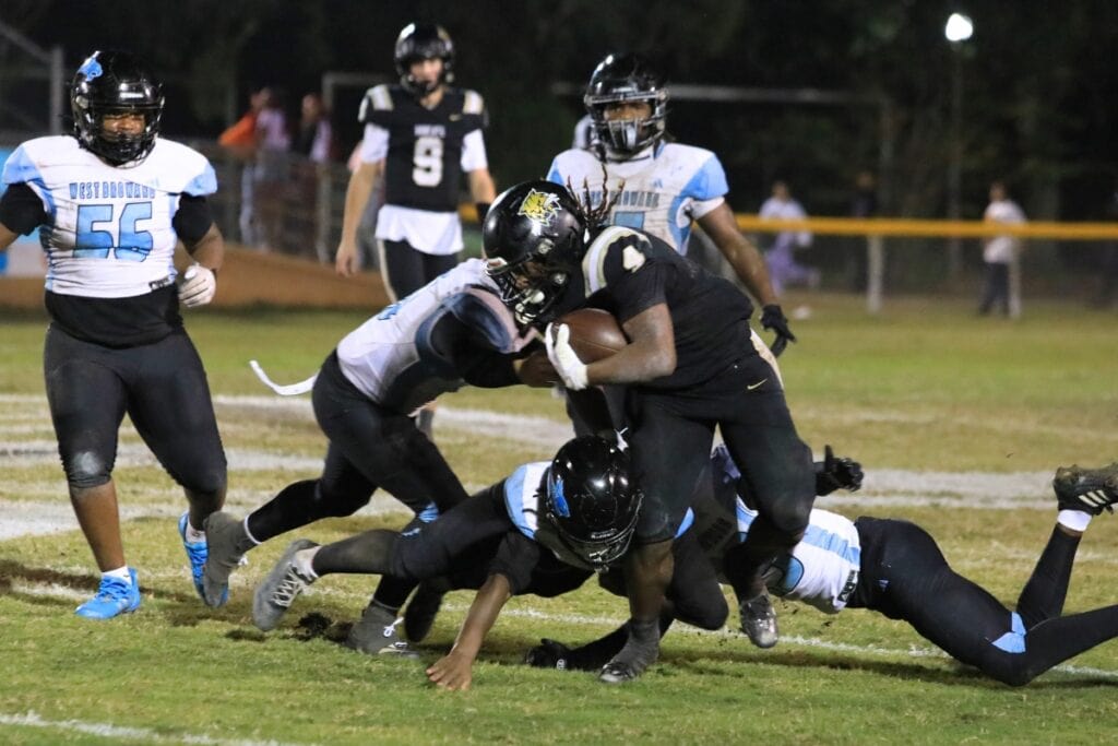 Josh Menefee is tackled by West Broward defenders during a run.