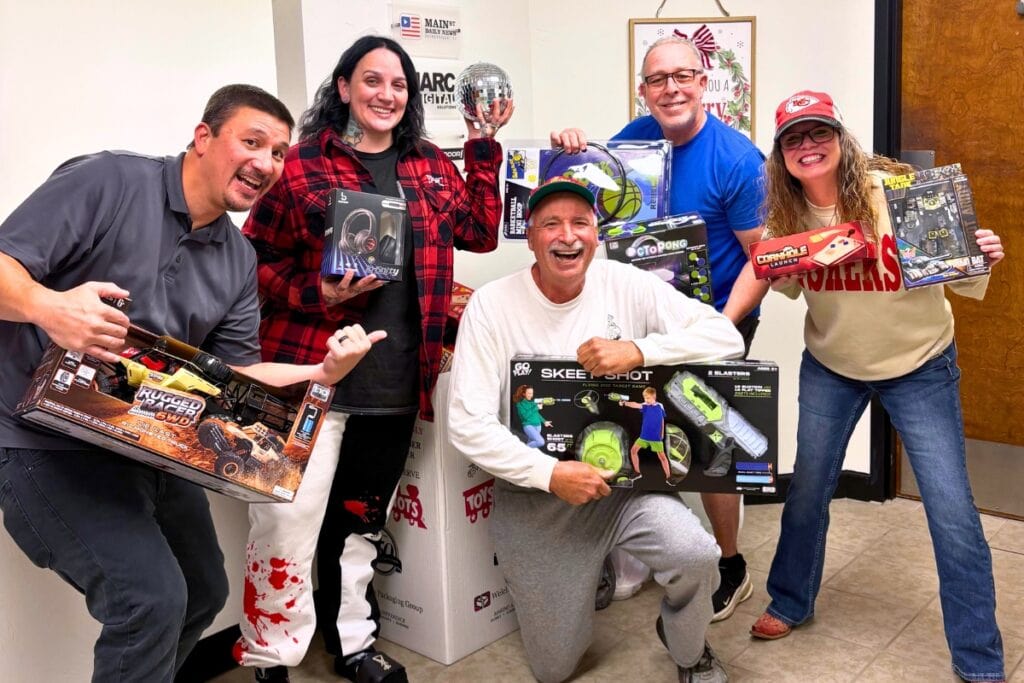 MARC Media staff smile with Lennart Lilcholm (center), who made a large Toys for Tots donation. Photo by Analicia Pilla