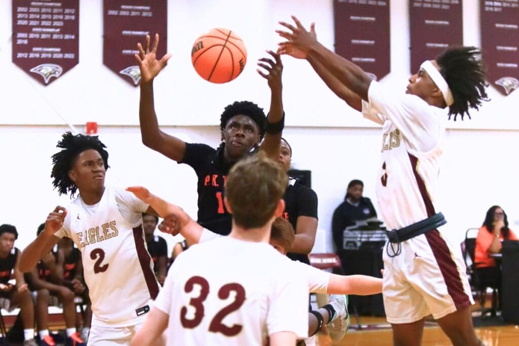P.K. Yonge's Eugene Hall (10) battles for a rebound against Oak Hall's Correy Brooks Jr. (2) and Amari Ray (3). Photo by C.J. Gish