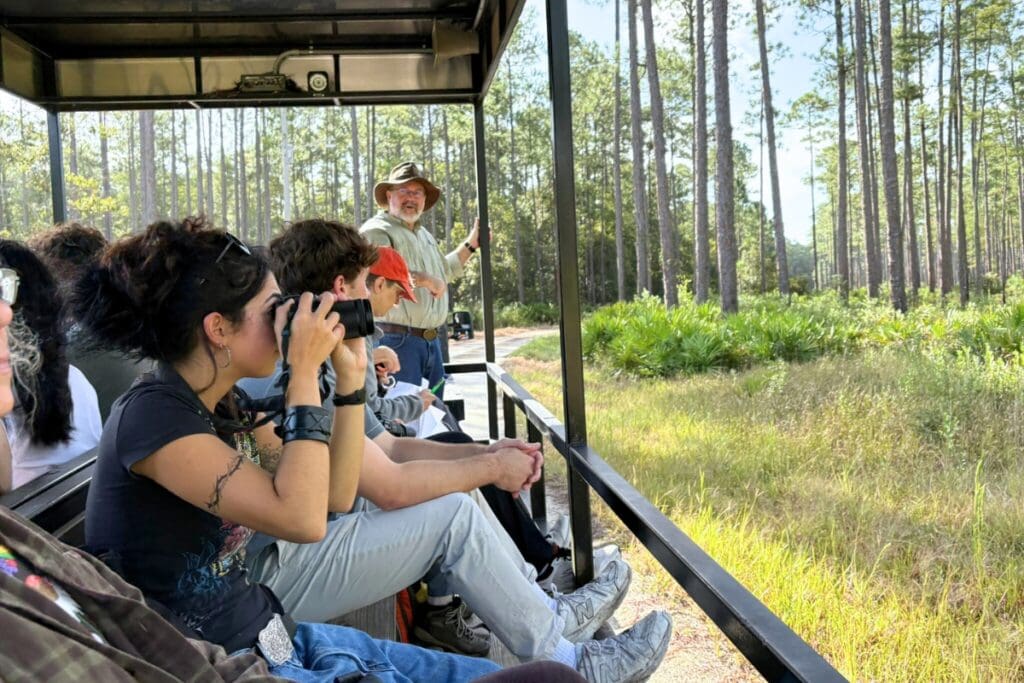 SFFGS Assistant Director Scott Sager speaks to Video Art students as they ride on a tram through the Austin Cary Forest. Photo by Suzette Cook - UF-IFAS